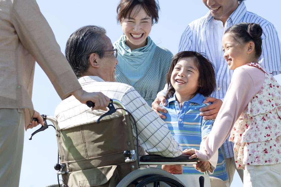 車椅子の男性と家族